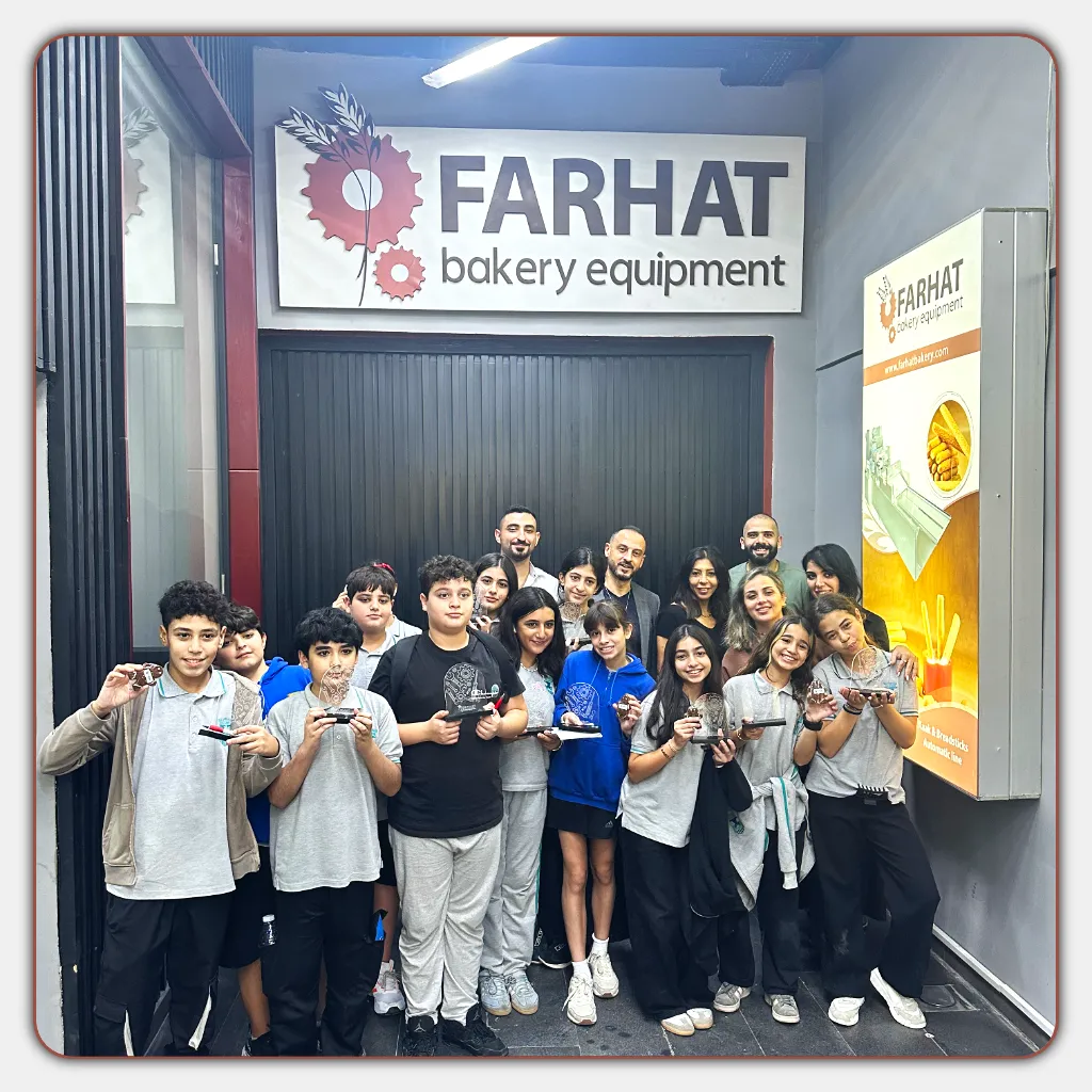 Group of Eastwood College students visiting Farhat Bakery Equipment factory, holding custom-made souvenirs during an educational tour.